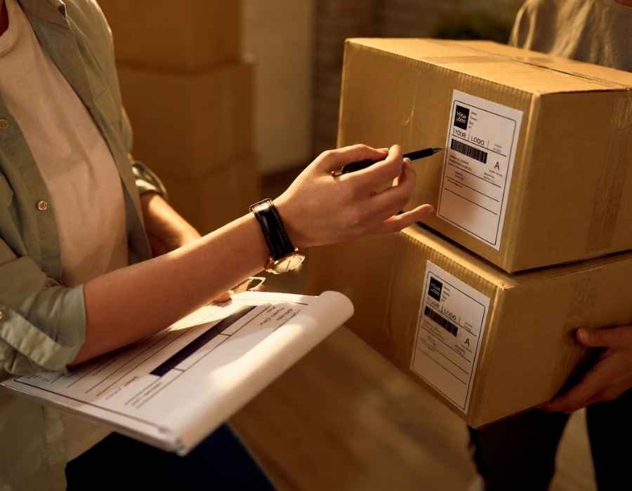 Returns specialist inspecting package labels and documenting returned inventory for processing